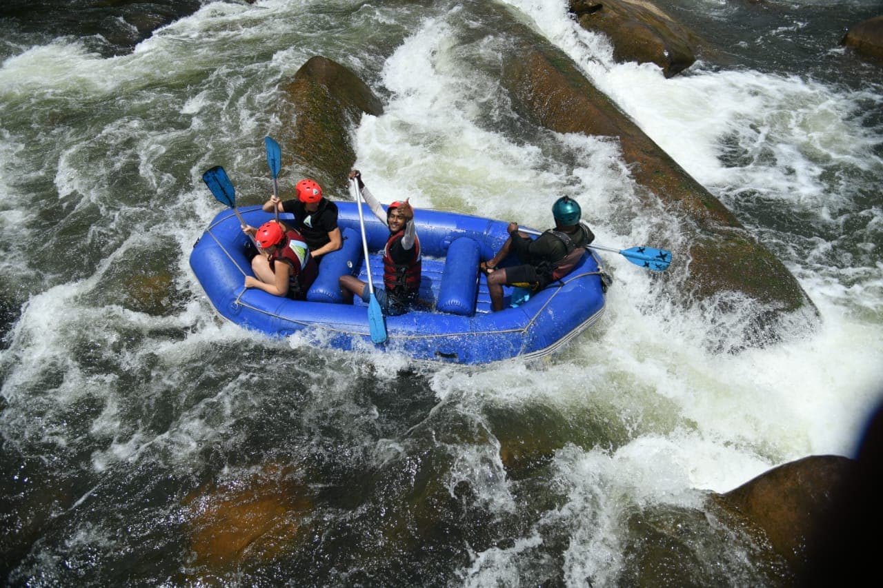 Guide leading a raft team through high-water river rapids